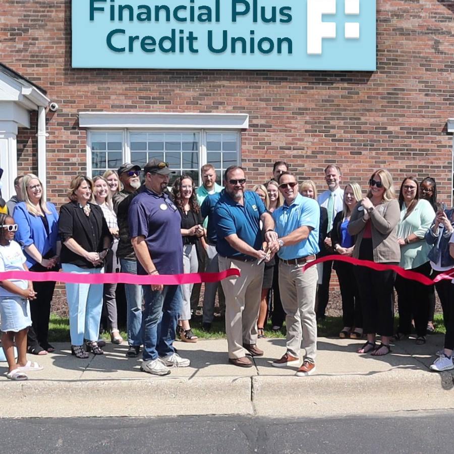 Financial Plus team and community members cutting ribbon outside of Flushing branch.