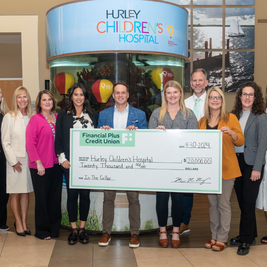 Financial Plus Credit Union's Executive Team presents Hurley Children's Hospital with a check for $20,000.